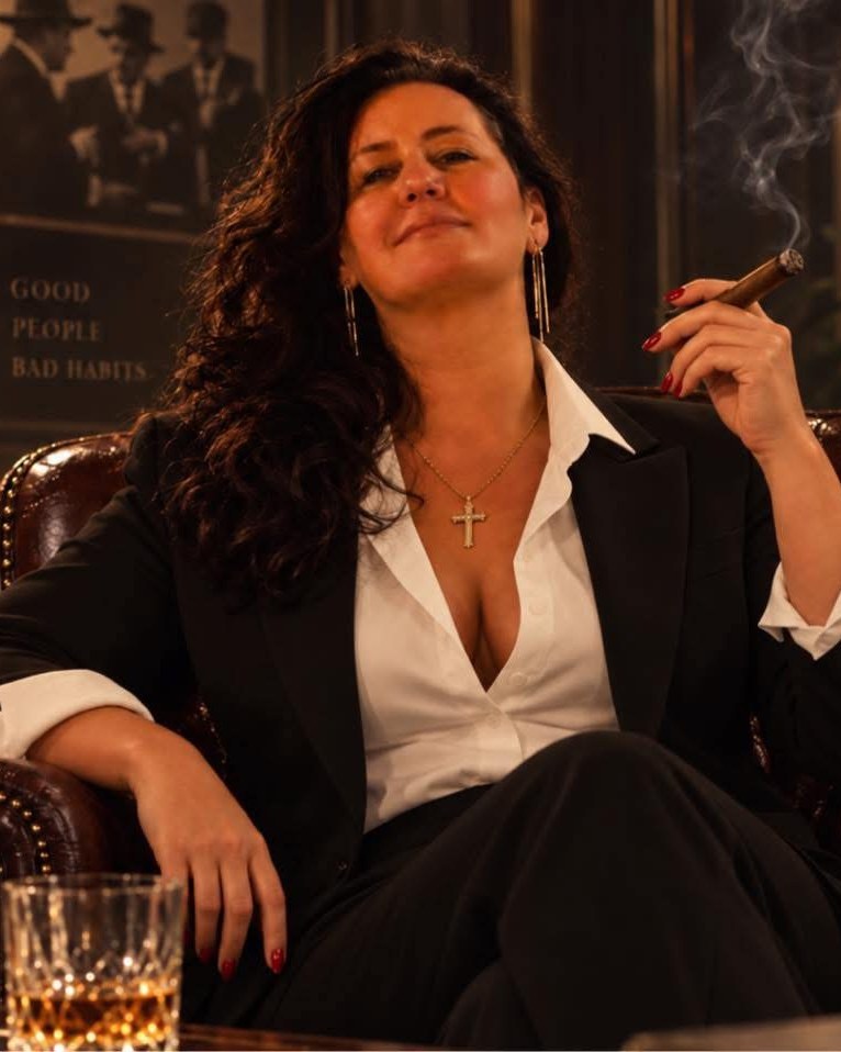 Our lead creative at work, styled in a tailored black suit with bold red nails