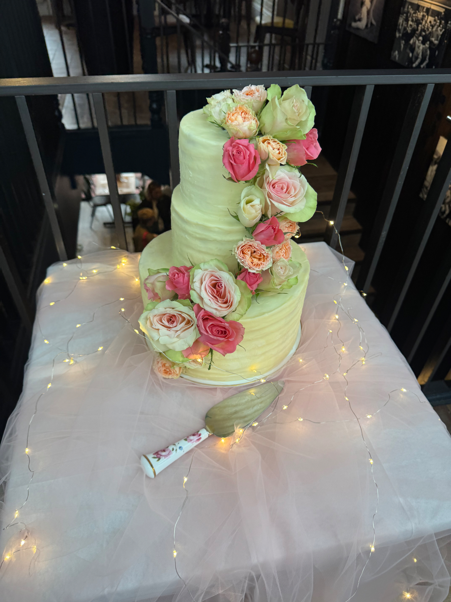 Three-tier white wedding cake with hand-piped sugar peonies